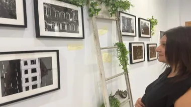 Fotografías en blanco y negro siendo observadas por Susana Rivas.