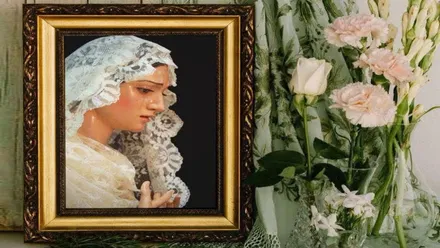 Cartel con un cuadro con la imagen de la Virgen de la Esperanza y un ramo de flores a su derecha.