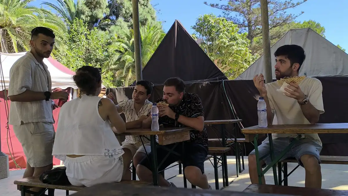 Un grupo de cinco estudiantes comen en el templete del Parque Genovés durante el Mercado Romano.