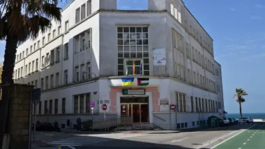 Fachada del IES Columela de Cádiz con las banderas de Ucrania y Palestina.