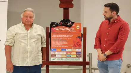 Los organizadores junto al cartel de este concurso de Fandangos de Rota, en tonos rojizos.