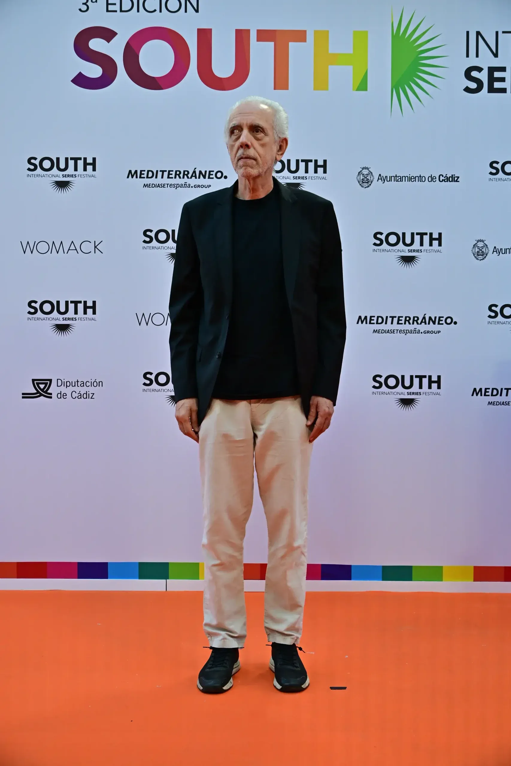 Fernando Trueba, de pie ante los medios, posando en la alfombra roja.