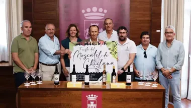 Organizadores y fuerzas municipales posando junto al cartel de la Fiesta del Moscatel en Chiclana.