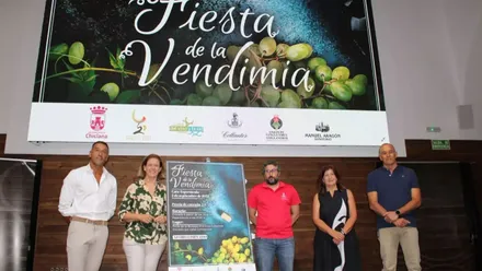 Delegada municipal Manuela Pérez junto a los organizadores y el cartel de la Fiesta de la Vendimia.