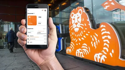 Mano sosteniendo teléfono móvil con comunicación de ING.