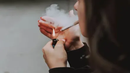 Chica encendiendo un cigarrillo.