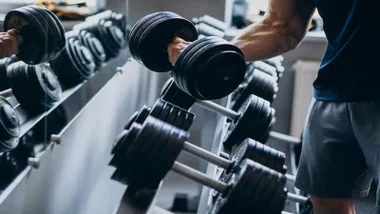 Persona haciendo pesas en un gimnasio.