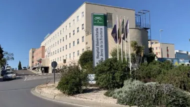 Rotonda del hospital de Jerez con banderas y el edificio al fondo.