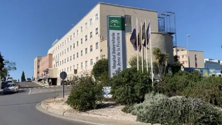 Rotonda del hospital de Jerez con banderas y el edificio al fondo.