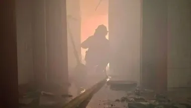 Silueta de un bombero en la casa incendiada en Chiclana.