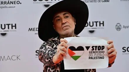 Juba Cucarella en la alfombra roja con un cartel contra el genocidio en Palestina.