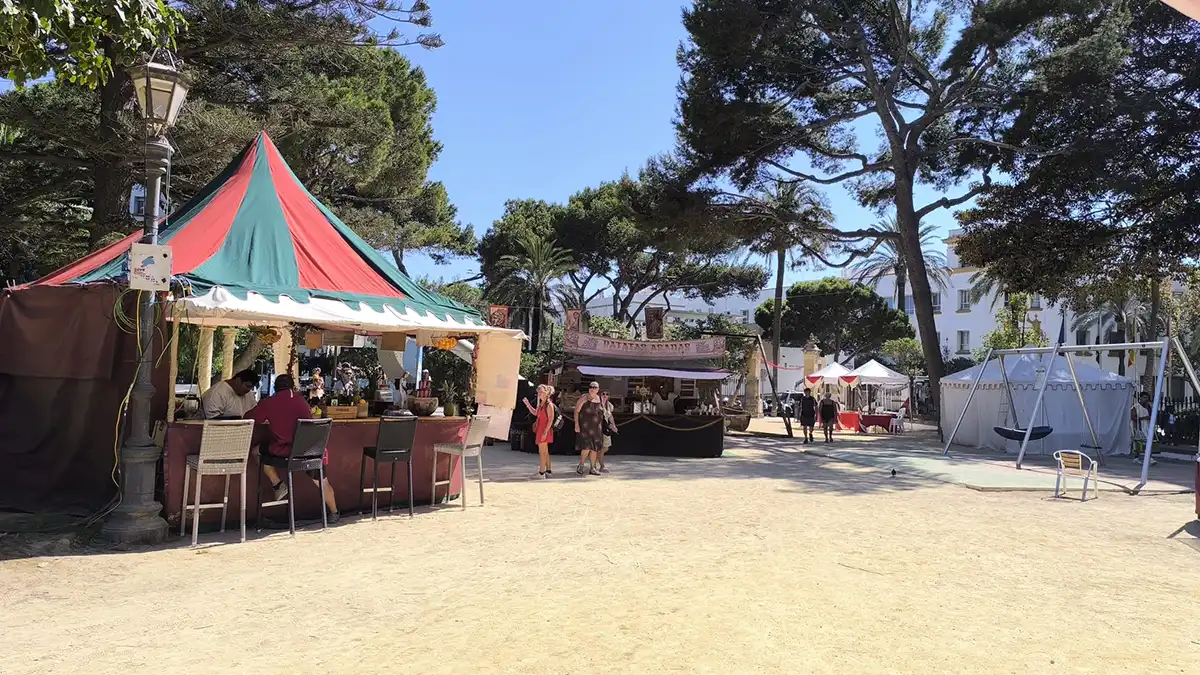 Puesto de mojito de litros, puestos de patatas asadas y columpios infantiles uno al lado del otro en el Mercado Romano del Parque Genovés.