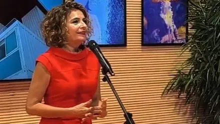 María Jesús Montero, con vestido rojo, comunicando la información para los astilleros de Puerto Real.