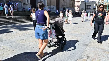 Una mujer pasea conn un con carrito de bebé por la plaza de la Catedral de Cádiz.