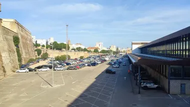 Cielo de Cádiz con pocas nubes en una imagen desde la estación de trenes con el aparcamiento de coches en primer término