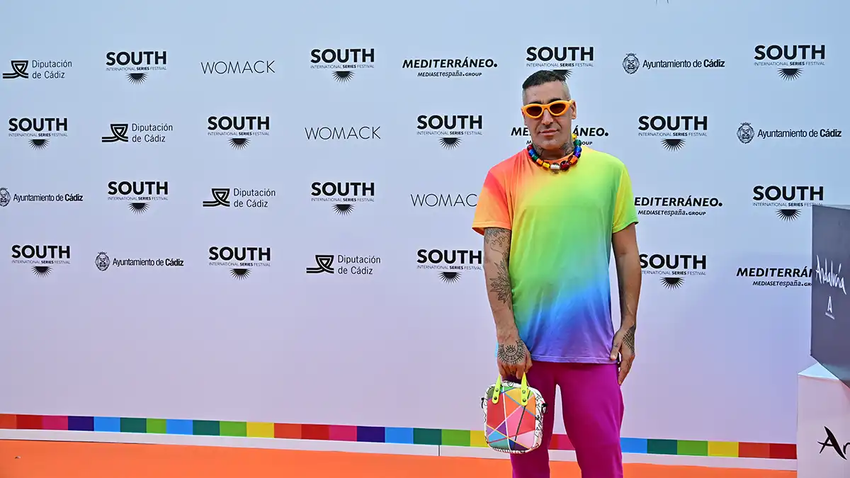 Okuda San Miguel posa junto a una reproducción de su cartel colorido.