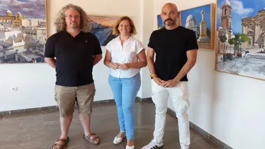 Agua Ariza junto a Manuela Pérez, delegada del Ayuntamiento, tras ellos los cuadros de la exposición.