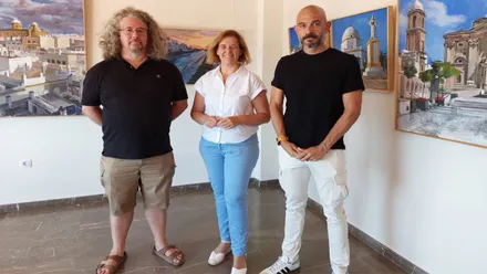 Agua Ariza junto a Manuela Pérez, delegada del Ayuntamiento, tras ellos los cuadros de la exposición.
