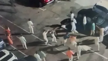 Vista elevada de un grupo de chicos peleándose en un aparcamiento.