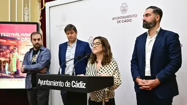 En la imagen aparecen cuatro personas durante la presentación del Festival de Manga de Cádiz 2025. Interviniendo, la concejala de Juventud e Infancia, Gloria Bazán, a su izquierda el concejal Carlos Lucero y junto a ellos representante de las asociaciones organizadoras, Miguel Gutiérrez, del Colegio San Felipe Neri, Agustín Merello.