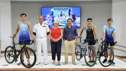Deportistas vestidos con ropa de triatlón junto a la delegada y al representante de la Armada Española.