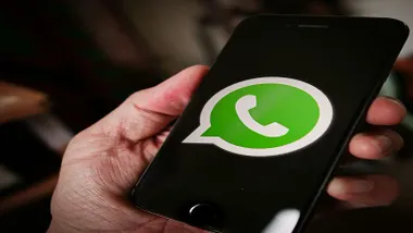 Una mano con un teléfono con la app de Whatsapp.
