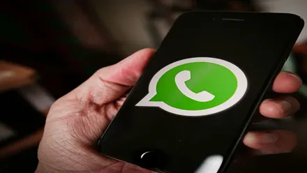 Una mano con un teléfono con la app de Whatsapp.