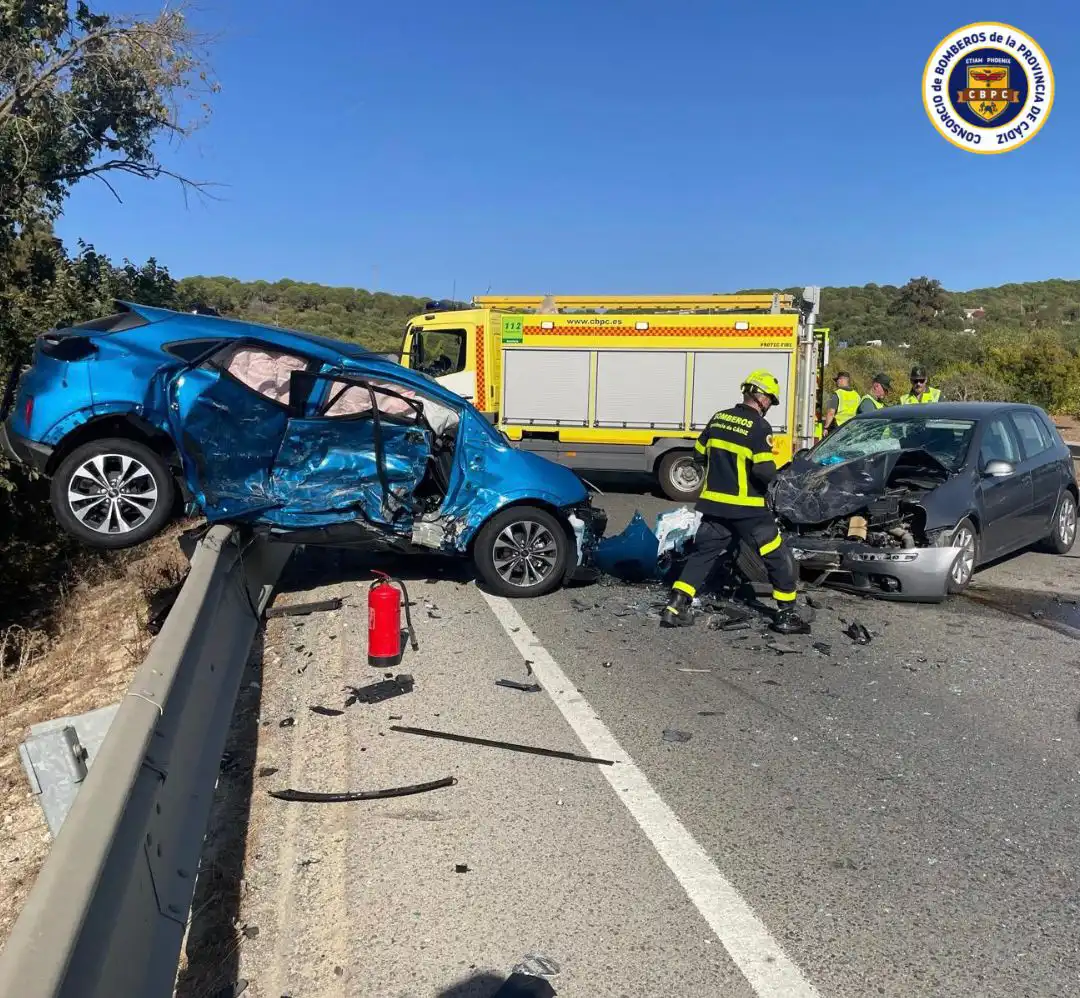 Bomberos del parque de Arcos trabajando entre los vehículos implicados en el accidente en la A-384.