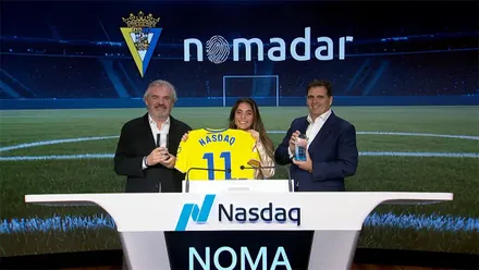 Acto de inicio de la cotización de Nomada, con la presentadora posando con una camiseta del Cádiz junto al presidente y el vicepresidente de la entidad, Manuel Vizcaíno y Rafael Contreras.