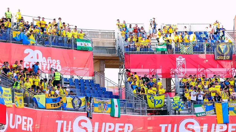 Aficionados del Cádiz CF en la grada visitante del estadio Nuevo Los Cármenes durante el partido ante el Granada CF, el mismo momento en que la Plataforma Estadio Carranza enviaba su comunicado pidiendo reactivar el cambio de nombre del estadio.
