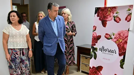 Antonio Sanz, Mercedes Colombo y Eva Pajares llegan a una reunión con asociaciones de mujeres en Cádiz. En la imagen, Sanz observa un cartel del aceite solidario de Agamama.