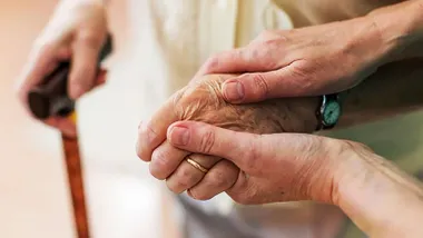 Mano de una mujer joven sosteniendo la mano de una anciana, muy simbólica de la ayuda.