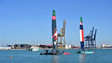 Varios catamaranes F50 de la SailGP navegando frente al muelle de Cádiz durante los entrenamientos oficiales previos a las regatas, con el cielo despejado y el puerto al fondo
