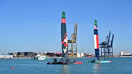 Varios catamaranes F50 de la SailGP navegando frente al muelle de Cádiz durante los entrenamientos oficiales previos a las regatas, con el cielo despejado y el puerto al fondo