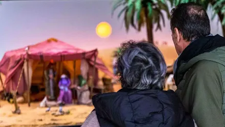 Dos personas admiran un portal de Belén en San Fernando.