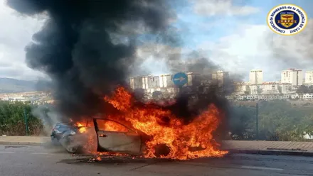 Coche negro envuelto en llamas.