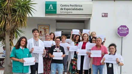 La imagen muestra a una docena de profesionales sanitarios y delegados sindicales concentrados ante el Centro Periférico de Salud La Longuera (Chiclana de la Frontera). Portan pancartas con mensajes como “Tolerancia cero ante las agresiones” y “Respeto al personal sanitario”, en protesta por las amenazas y ataques sufridos por el equipo de Salud Mental.