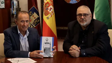 José María Román sostiene el libro en sus manos junto al autor José Luis Márquez Fernández.