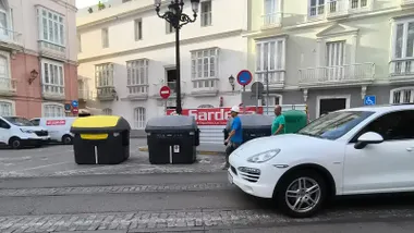 Contenedores de basura amarillos, grises y verdes en una calle de Cádiz