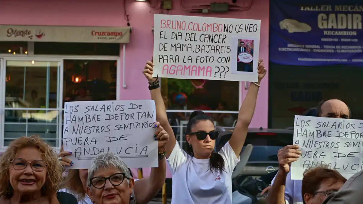 Una joven participante en esta movilización muestra una pancarta alusiva a Agamama con el texto "Bruno, Colombo, no os veo. ¿El día del cáncer de mama bajaréis a echaros la foto con Agamama?".