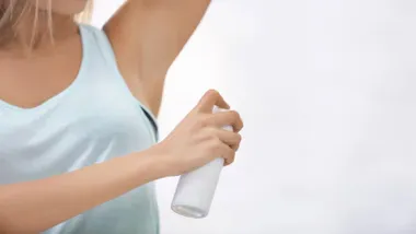 Mujer echándose desodorante.