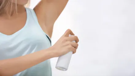 Mujer echándose desodorante.