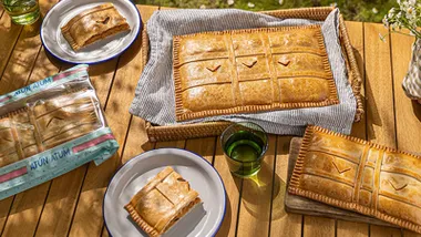 Diferentes empanadas de atún sobre una mesa de madera.