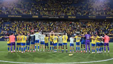El Cádiz CF celebra con su afición la victoria ante la SD Huesca. Se ven banderas cadistas, andaluzas y palestinas en el Fondo Sur del Nuevo Mirandilla.