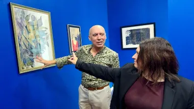 Sala azul con Jesús Romero y Susana Rivas admirando un cuadro.