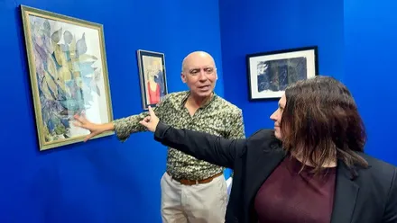 Sala azul con Jesús Romero y Susana Rivas admirando un cuadro.
