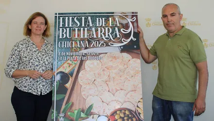 Manuela Pérez junto a Blas Ramírez y, en medio, el cartel de la Fiesta de la Butifarra de Chiclana.
