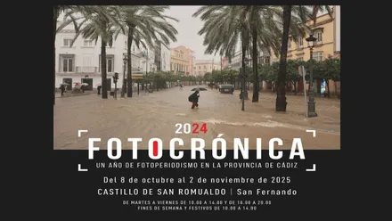 Cartel "Fotocrónica 2024" en San Fernando, plaza arreciada por el viento y la lluvia.