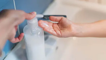 Persona lavándose las manos con un gel de ph neutro.
