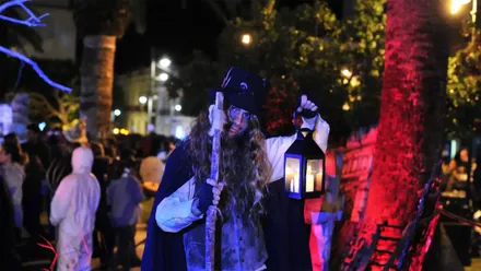 Hombre caracterizado de brujo con un farol en San Fernando.